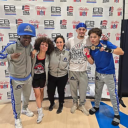Blue Boy boxers celebrating with a championship belt